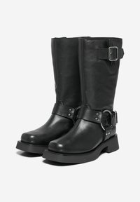 Stivali neri in pelle fino al ginocchio con punta quadrata, dettagli con fibbia e cinturino, minuteria rotonda in argento e suole spesse in gomma.