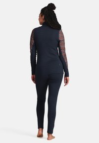 Navy Strickoberteil mit gemusterten Ärmeln und passenden, figurbetonten Hosen. Verfügt über einen hohen Ausschnitt und eine glatte Textur. Minimalistisches Design und keine sichtbaren Verschlüsse.