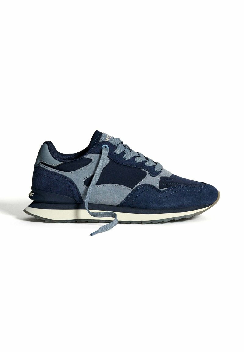 Mannen sportieve sneakers in marineblauw en grijs met gemengde stoffen panelen, loshangende veters en een witte zool met een zwarte loopvlak.