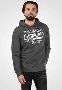 Grijze capuchontrui met een voorbedrukking van "New York City Superior Basketball Tournament Since 1982" in het wit. Casual fit, zachte textuur.
