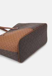 Sac à main marron et gris à motifs avec accents en cuir, forme rectangulaire, deux bretelles d'épaule et détails en métal doré.