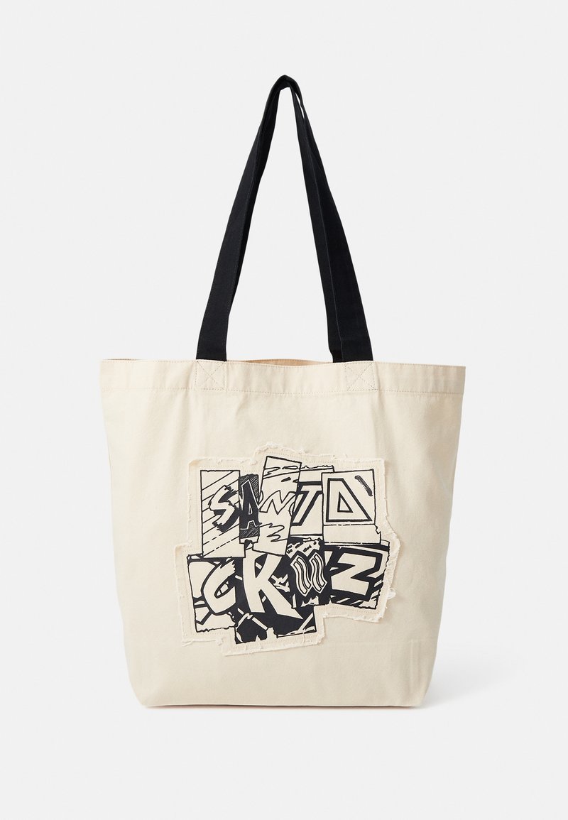 Sac cabas beige avec poignées noires présentant un design graphique noir et blanc de style patchwork avec des lettres stylisées.