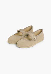Zapatos de ante beige estilo Mary Jane, con punta redonda, borde cosido y una correa con cierre de botón. Suela plana.