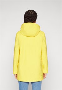 Yellow waterproof jacket with a hood, long sleeves, and straight cut. Smooth texture, mid-length, and side pockets.