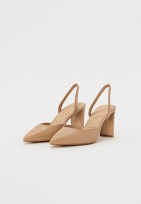 Nude-nahan nahka-slingback-kengät, joissa on terävä kärki ja lohkare korko. Kengissä on sileä pintamateriaali ja minimalistinen muotoilu.
