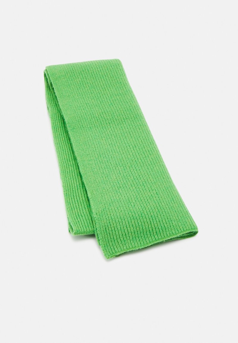Écharpe en tricot côtelé vert vif pliée sur un fond blanc.