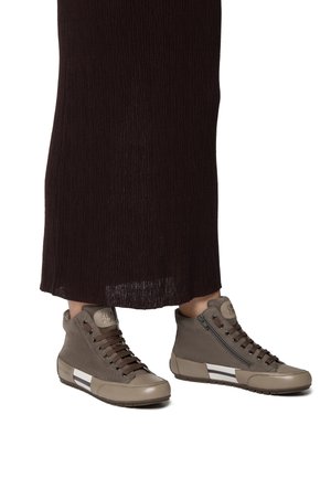 Sneaker alte grigie in suede con punta lucida, dotate di lacci marroni e una cerniera laterale, accentuate da strisce bianche.