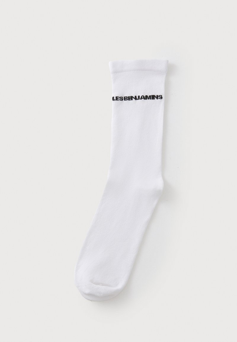Chaussette blanche de type crew avec une texture douce ; présente le texte noir "LES BENJAMINS" près du bord. Coupe droite avec un design à bout fermé.