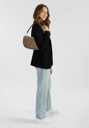Schwarze, taillierte Blazer über hellblauen, weiten Jeans, kombiniert mit einer geschwungenen, braunen Handtasche und weißen Plateauschuhen. Sanfte Texturen durchgängig.
