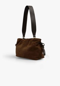 Bolso de ante marrón con un diseño suave y flexible, que cuenta con una correa de cuero oscuro y detalles sutiles en metal. Forma compacta y versátil.