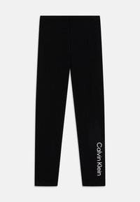 Čierne legíny vyrobené z mäkkého, elastického materiálu s hladkým povrchom. Logo "Calvin Klein" vytlačené v bielej farbe na dolnej časti nohy.