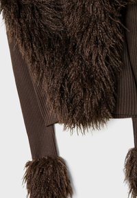 Maglione corto marrone con texture a coste e lunghi accenti di pelliccia sintetica shaggy sul collo e sulle maniche.