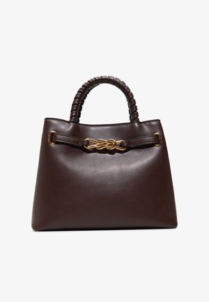 Donkerbruine lederen handtas met gevlochten handvat en een decoratieve gouden knoopdetail op de voorkant van de riem, geplaatst tegen een witte achtergrond.