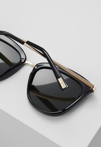 Le Specs CALIENTE  - Zonnebril - black/gold-coloured