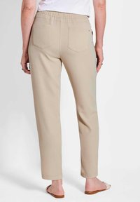 Beige, elastische taillebroek met een slim fit, twee achterzakken en een gladde textuur, eindigend net boven de enkel met een gezoomde rand.