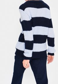 Navy and light blue striped knit sweater with long sleeves, a round neckline, and ribbed cuffs. Textured yarn, relaxed fit design.