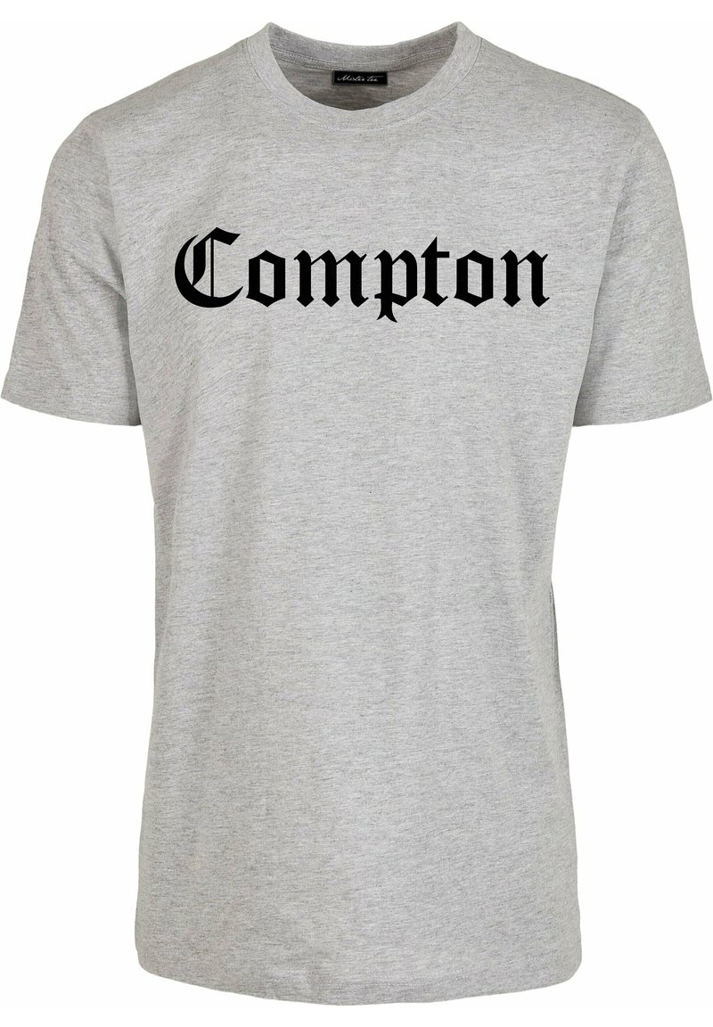 Lichtgrijs T-shirt met korte mouwen en ronde hals, met "Compton" in grote zwarte Old English letters gecentreerd op de voorkant.