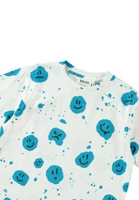 Vit bomulls t-shirt med blå cirkulära mönster med leende och sura ansikten. Rund halsringning och korta ärmar. Molo-logotyp synlig.