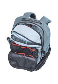 Rugzak gemaakt van gerecyclede materialen, met een lichtblauwe buitenkant, meerdere vakken, grijze accenten en oranje details op de zakken.