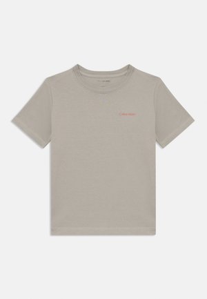 Sivá bavlnená tričko s krátkymi rukávmi a okrúhlym výstrihom. Na hrudi sa nachádza malá červená logo "Calvin Klein". Hladká textura.