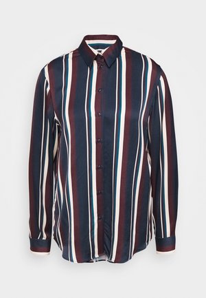 Chemise à manches longues boutonnée, à rayures verticales bleu marine, bordeaux, blanches et bleu sarcelle, sur un fond uni.