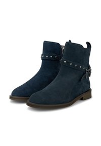 Botines de ante azul marino con cremallera lateral, correa decorativa con tachuelas plateadas y suela de goma plana. Textura suave y punta redondeada.