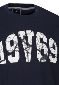 Navyblauwe t-shirt met grote witte gebarsten typografie "1969" op de voorkant. Ronde ronde hals en korte mouwen.