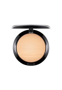 Poudre pressée MAC dans un compact rond noir. La poudre est beige clair avec des lignes horizontales gravées et des détails du logo. S'ouvre avec une charnière.