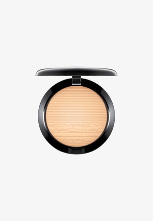 Poudre pressée MAC dans un compact rond noir. La poudre est beige clair avec des lignes horizontales gravées et des détails du logo. S'ouvre avec une charnière.