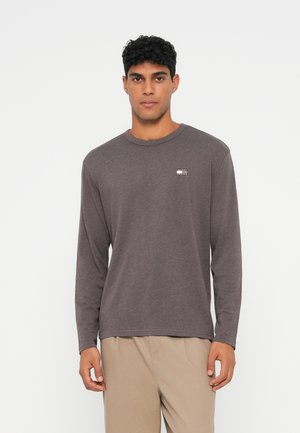 Grijs shirt met lange mouwen in een zachte, lichte stof, met een ronde hals en een klein logodetail op de linker borst. Comfortabele pasvorm.