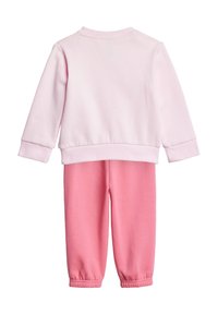 Sweatshirt en coton rose avec des poignets côtelés, associé à un pantalon de jogging rose assorti avec des bords élastiques, une texture douce et une coupe décontractée.