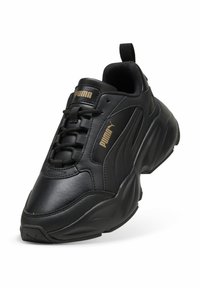 Schwarzer Sportschuh aus synthetischem Leder. Verfügt über ein Schnürdesign, einen weich gepolsterten Kragen und goldene Logoakzente auf der Zunge und der Seite.
