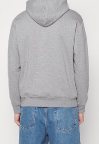 Gray hoodie made of soft fabric with a kangaroo pocket, featuring a ribbed hem and cuffs. Designed with a drawstring hood.