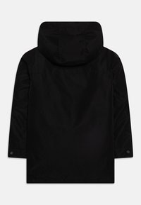Chaqueta exterior negra con capucha, con una textura de tela suave, mangas largas y un corte recto. Botones a presión en los puños.
