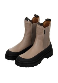 Beige ankle boots with black rubber sole, elastic side panels, and pull tabs; smooth finish with contrasting stitching details.