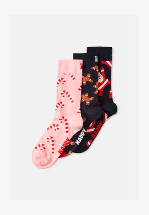 Tres pares de calcetines: rosa con bastones de caramelo, azul marino con pan de jengibre y azul marino oscuro con Santa, todos con patrones coloridos y textura de punto.