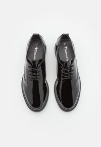 Scarpe stringate in vernice nera con punta rotonda, suola texturizzata e un marchio discreto all'interno. Taglia segnata come 37.