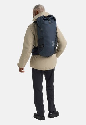 Rückansicht eines Navy-Rolltop-Rucksacks aus strapazierfähigem Material, mit seitlichen Netztaschen, verstellbaren Trägern und einem schlanken, modernen Design.