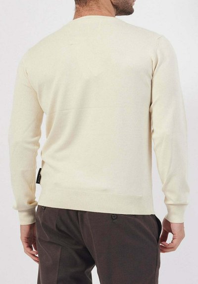 Maglione color crema con una texture a maglia fine, scollo a girocollo, polsini e orlo a costine, e una piccola etichetta sul lato.