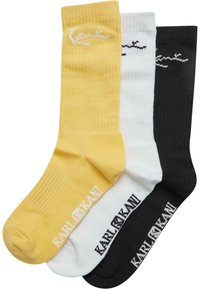 Drei Paar Crew-Socken aus Baumwolle in Gelb, Weiß und Schwarz, mit geripptem Textur und Logo-Druck am Bund in kontrastierender Farbe.