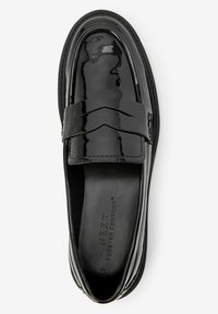 Mocassino in vernice nera con punta arrotondata, caratterizzato da un accento a forma di V rialzato sulla fascia e una soletta imbottita.
