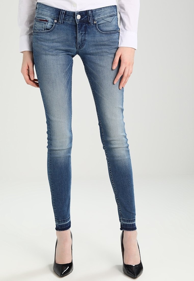Jeans ajustados de color azul con un acabado desgastado, que cuentan con un cierre de gancho y cremallera, cinco bolsillos, costuras en contraste y una silueta estrecha.