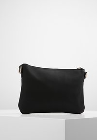 Czarna skórzana torba z zamkiem błyskawicznym i gładką teksturą. Charakteryzuje się prostym wzornictwem oraz srebrnym metalowym akcentem z boku.