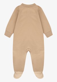 Langes, ärmelloses Baby-Overall mit Füßen, rundem Kragen und gerippten Bündchen. Aus weicher Baumwolle gefertigt, mit glatter Textur und nahtlosem Rücken.