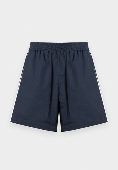 Σπορ σορτς σε ναυτικό μπλε χρώμα με ελαστική μέση. Λευκές πλαϊνές ρίγες, ελαφρύ ύφασμα και άνετη εφαρμογή με ίσια παντελόνια.