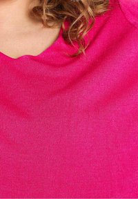 Fuksia kimono ylle, jossa on sileä kangas, laaja pyöreä kaula-aukko ja lyhyet hihat. Materiaali näyttää joustavalta ja kevyeltä.