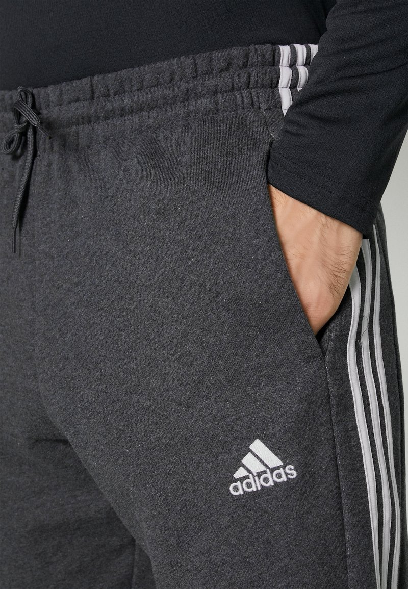 grey adidas joggers with black stripes
