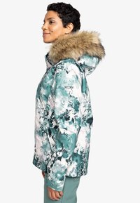 Jas met bloemenprint in teal en wit, met een nepbont gevoerde capuchon en Roxy-logo op de borst. Inclusief ritszakken.