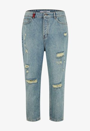 Lyseblå denimjeans med slitte detaljer, som har flere hull, fem-lommers design og et rødt merke i midjen.
