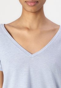 Maglietta V-neck azzurro chiaro realizzata in un tessuto morbido e leggero con maniche corte. Presenta una vestibilità comoda e una texture effetto melange discreta.